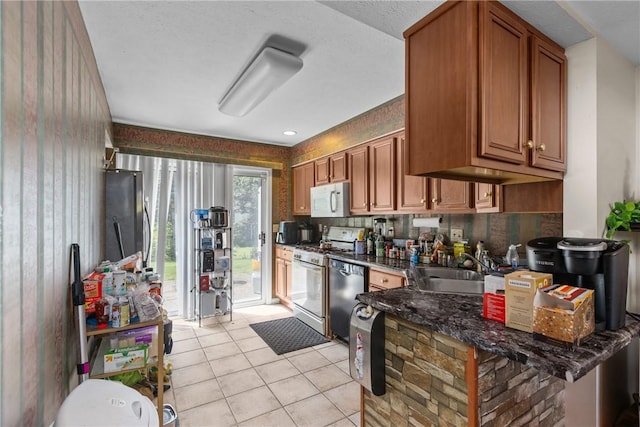 302 Malcolm Ct, Monroeville, PA 15146 - kitchen with white appliances, dark countertops, light tile patterned floors, and brown cabinetry