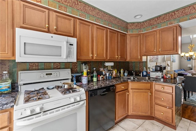 302 Malcolm Ct, Monroeville, PA 15146 - kitchen featuring white appliances, a chandelier, brown cabinets, and dark stone countertops