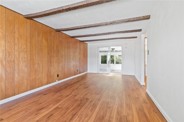 718 Twin Oak Dr, Penn Hills, PA 15235 - empty room featuring beamed ceiling, wooden walls, wood finished floors, and a ceiling fan