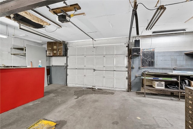 2509 Thomas St, Hempfield Twp, PA 15634 - garage featuring a garage door opener and concrete block wall