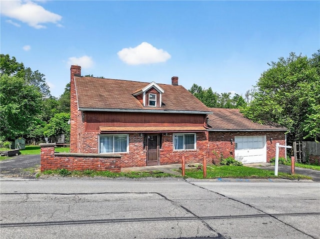 2509 Thomas St, Hempfield Twp, PA 15634 - view of front facade with a garage, a chimney, brick siding, and driveway