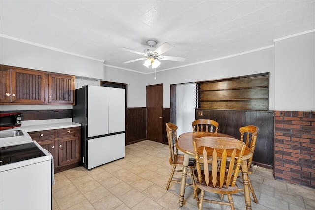2509 Thomas St, Hempfield Twp, PA 15634 - kitchen with range, freestanding refrigerator, black microwave, a ceiling fan, and a wainscoted wall