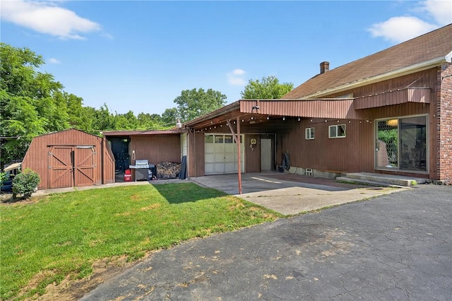2509 Thomas St, Hempfield Twp, PA 15634 - rear view of house featuring a yard, an attached garage, asphalt driveway, a storage shed, and an attached carport