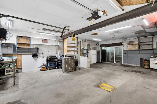 2509 Thomas St, Hempfield Twp, PA 15634 - garage featuring freestanding refrigerator, a garage door opener, and a workshop area