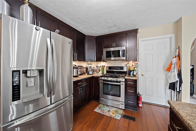 1071 Shawnee Ridge Dr, Cheswick, PA 15024 - kitchen with stainless steel appliances, dark wood-style floors, dark brown cabinetry, light stone countertops, and tasteful backsplash