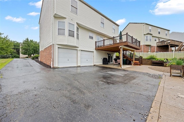1071 Shawnee Ridge Dr, Cheswick, PA 15024 - back of property with stairs, an attached garage, a wooden deck, asphalt driveway, and brick siding