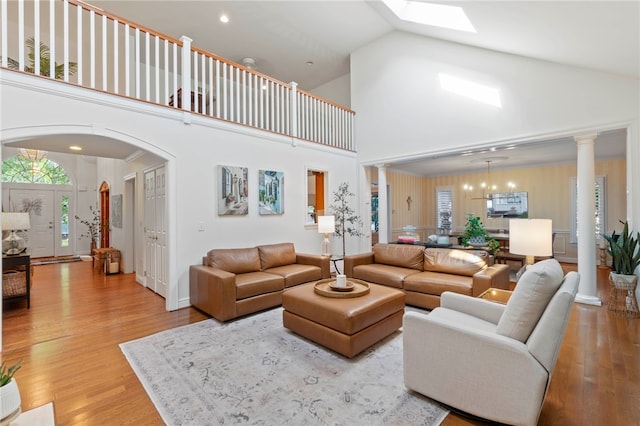 1413 Oak St, Oakmont, PA 15139 - living area featuring wood finished floors, high vaulted ceiling, ornate columns, arched walkways, and a skylight