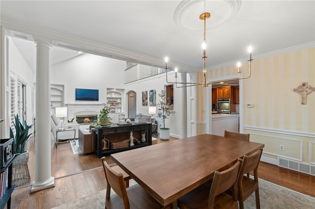1413 Oak St, Oakmont, PA 15139 - dining room with built in features, crown molding, a lit fireplace, wood finished floors, and wainscoting