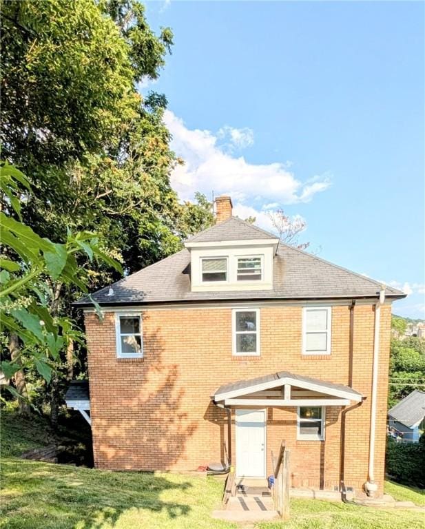 213 N 5th St, Jeannette, PA 15644 - view of front of home featuring brick siding, a front yard, and a chimney