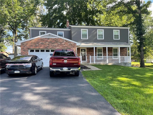 105 White Oak Dr, Twp Of But Se, PA 16001 - view of front of house featuring asphalt driveway, covered porch, brick siding, an attached garage, and a front yard