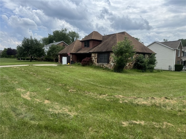 4401 Ridgewood Dr, Jefferson Hills, PA 15332 - view of side of property with an attached garage, a lawn, and stone siding