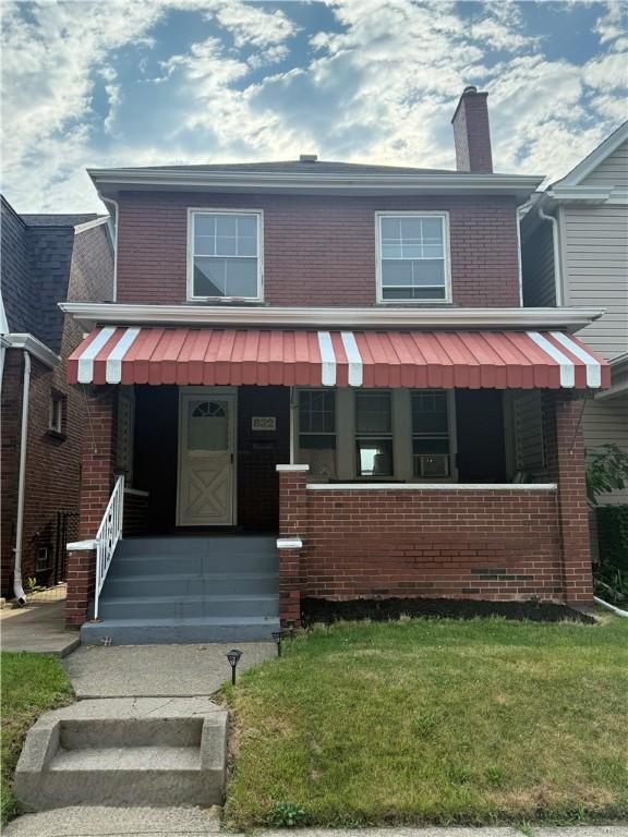 832 Maplewood Ave, Ambridge, PA 15003 - view of front of property with brick siding, a front lawn, and a chimney