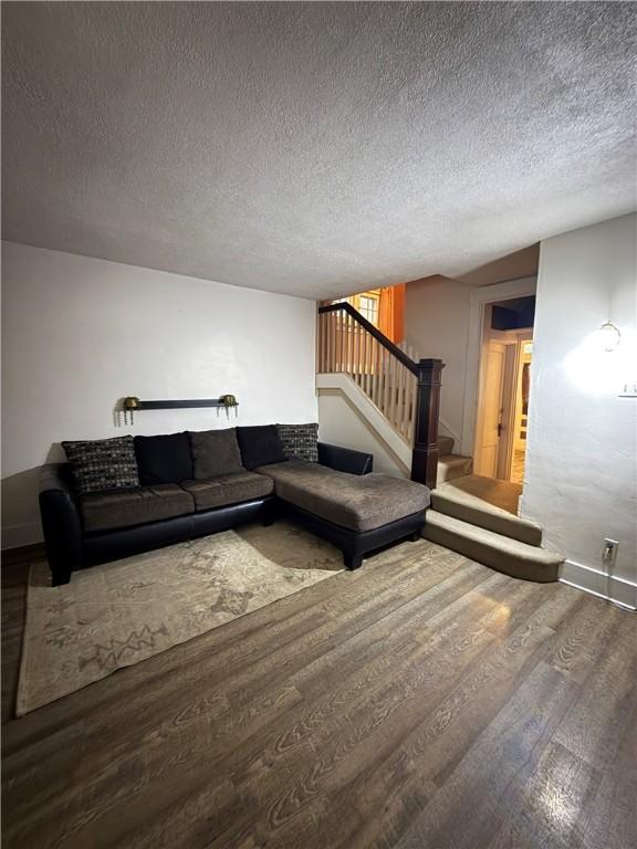 832 Maplewood Ave, Ambridge, PA 15003 - living room with wood finished floors, stairway, and a textured ceiling