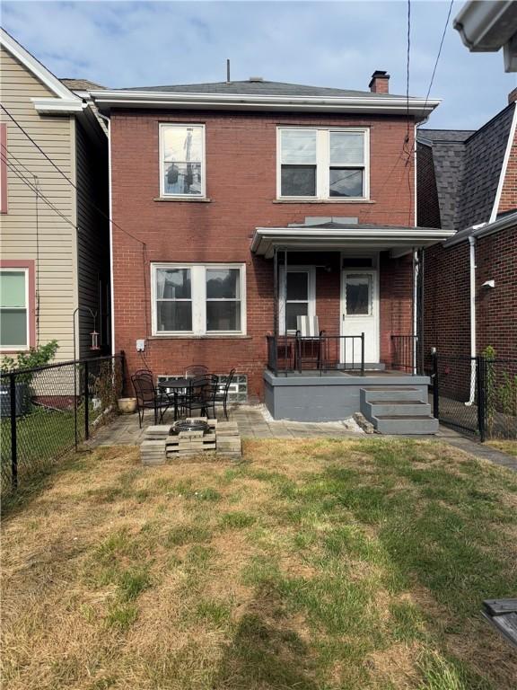 832 Maplewood Ave, Ambridge, PA 15003 - back of house featuring brick siding, a fenced backyard, a chimney, and a porch