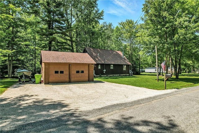8995 Puritan Ln, Conneaut Twp, PA 16424 - view of front of home featuring driveway, a front yard, view of wooded area, and roof with shingles