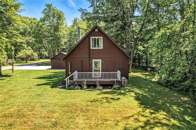 8995 Puritan Ln, Conneaut Twp, PA 16424 - view of front of property featuring a front lawn, a wooden deck, and a forest view