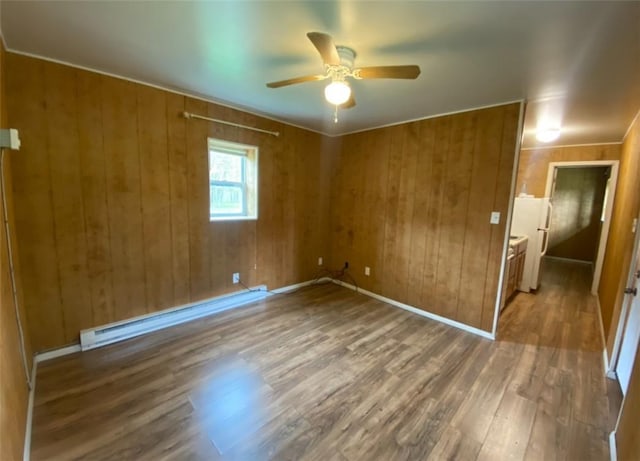 377 Mercer Rd, Hempfield Twp, PA 16125 - empty room with a baseboard radiator, a ceiling fan, wood finished floors, and wooden walls
