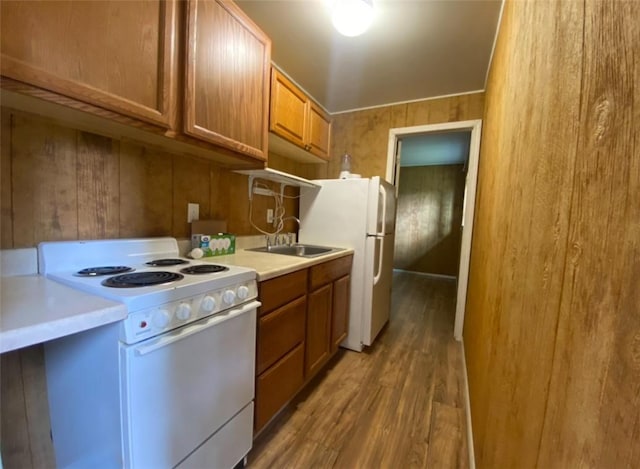 377 Mercer Rd, Hempfield Twp, PA 16125 - kitchen featuring white appliances, wood finished floors, brown cabinetry, light countertops, and wood walls