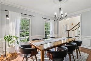 403 Worth Ct, Cranberry Twp, PA 16066 - dining room with a chandelier, crown molding, stairs, a wainscoted wall, and a decorative wall