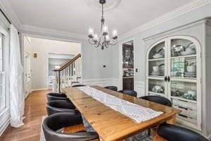 403 Worth Ct, Cranberry Twp, PA 16066 - dining room with a chandelier, stairs, crown molding, wood finished floors, and built in shelves