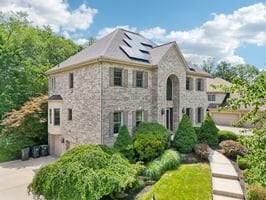 403 Worth Ct, Cranberry Twp, PA 16066 - view of front of home featuring solar panels, stone siding, concrete driveway, and an attached garage