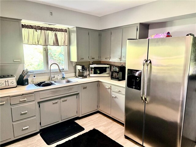 110 Surrey St, Monessen, PA 15062 - kitchen with appliances with stainless steel finishes, gray cabinets, light countertops, and light wood-style flooring