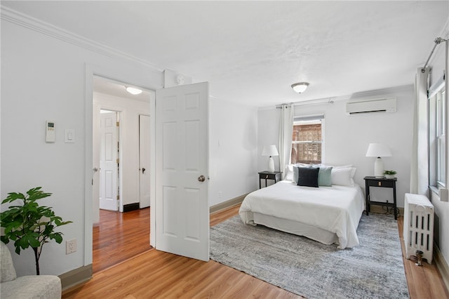 3863 Beechwood Blvd, Greenfield, PA 15217 - bedroom with a wall mounted air conditioner, radiator heating unit, light wood finished floors, and crown molding