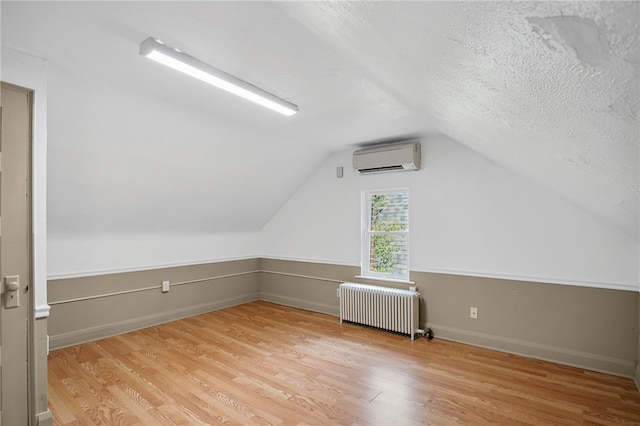 3863 Beechwood Blvd, Greenfield, PA 15217 - bonus room with radiator, a wall mounted air conditioner, light wood-style floors, lofted ceiling, and a textured ceiling
