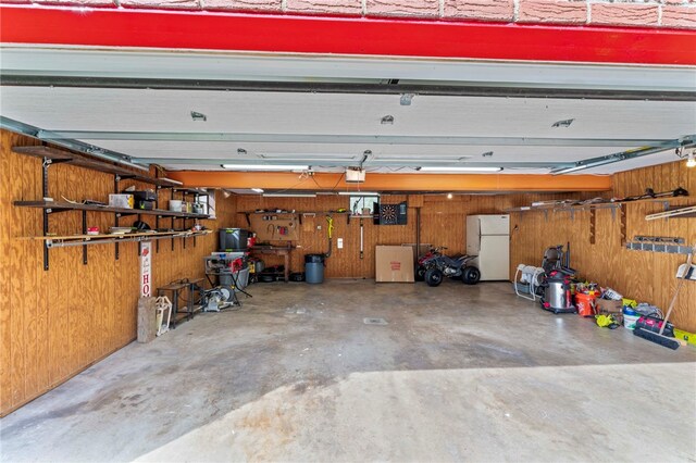 110 Steinbach Ln, Jefferson Hills, PA 15025 - garage featuring freestanding refrigerator, wooden walls, and a garage door opener