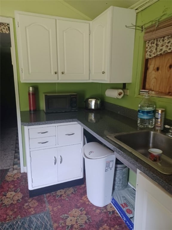 943 Walley Run Dr, Clarion, PA 16233 - kitchen featuring black microwave, dark countertops, white cabinetry, and lofted ceiling