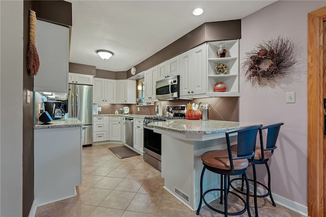 2666 Pointview Dr, Hampton, PA 15101 - kitchen featuring stainless steel appliances, a peninsula, white cabinetry, open shelves, and light stone countertops