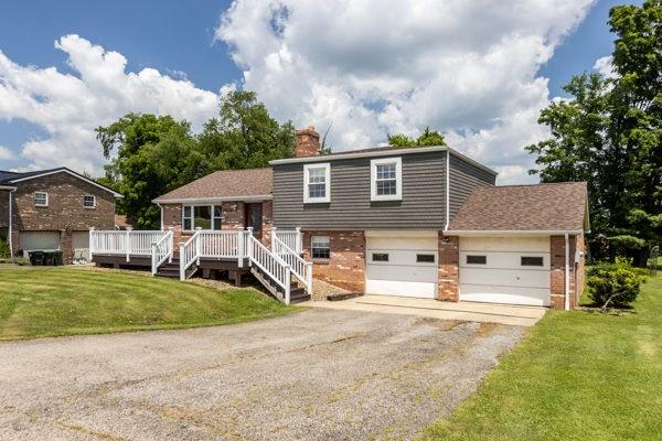 408 Circle Dr, Franklin Twp, PA 16117 - tri-level home with a chimney, asphalt driveway, a front lawn, brick siding, and a deck