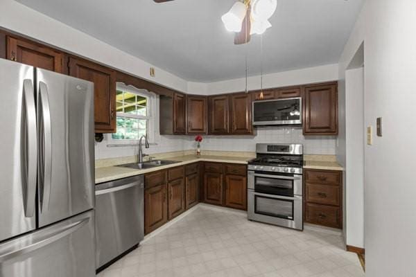 408 Circle Dr, Franklin Twp, PA 16117 - kitchen with appliances with stainless steel finishes, light countertops, decorative backsplash, a ceiling fan, and light flooring