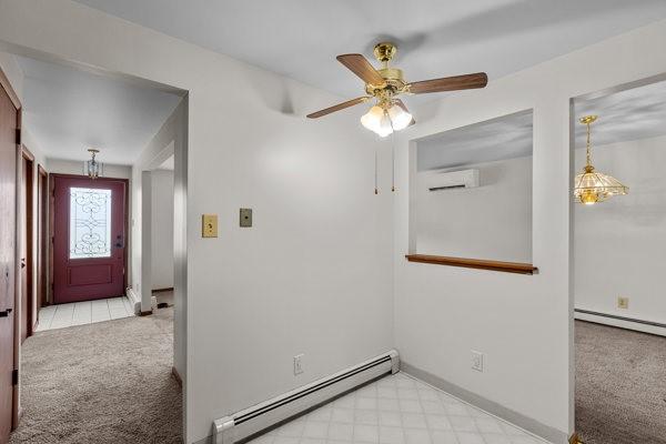 408 Circle Dr, Franklin Twp, PA 16117 - carpeted spare room featuring a baseboard radiator, a wall mounted air conditioner, and a ceiling fan