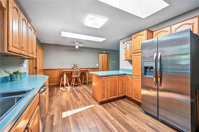2801 Valley View Rd, South Pymatuning Twp, PA 16150 - kitchen featuring stainless steel appliances, a skylight, a peninsula, wainscoting, and light wood-type flooring