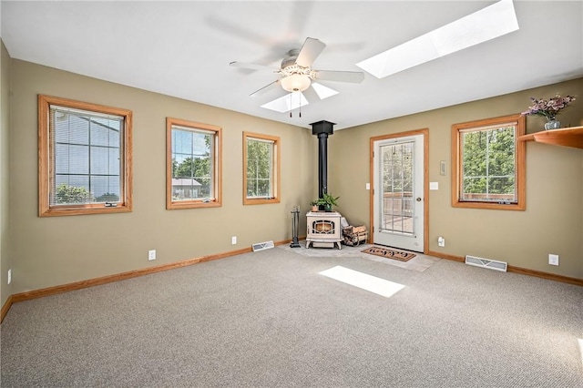 2801 Valley View Rd, South Pymatuning Twp, PA 16150 - carpeted spare room with a wood stove, a skylight, and ceiling fan
