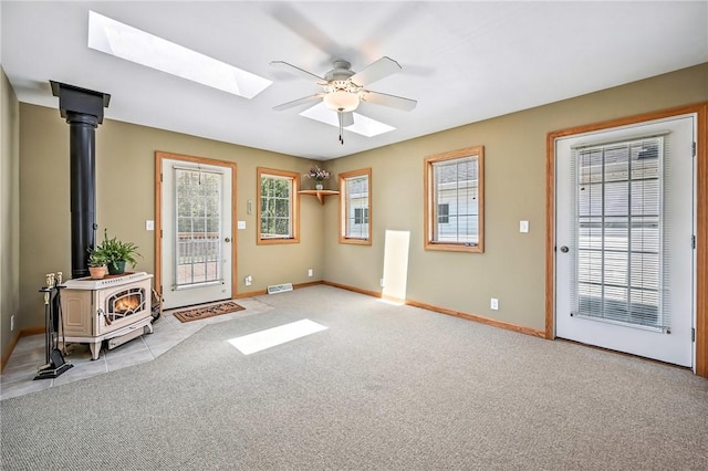 2801 Valley View Rd, South Pymatuning Twp, PA 16150 - entrance foyer featuring a wood stove, a skylight, a ceiling fan, light carpet, and light tile patterned floors