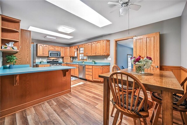2801 Valley View Rd, South Pymatuning Twp, PA 16150 - kitchen with stainless steel appliances, light wood-style flooring, ceiling fan, a skylight, and a peninsula