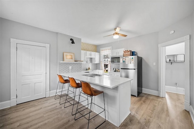 11 Walnut St, Crafton, PA 15205 - kitchen featuring stainless steel appliances, a peninsula, a kitchen breakfast bar, white cabinets, and light countertops