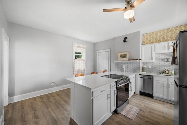 11 Walnut St, Crafton, PA 15205 - kitchen featuring stainless steel appliances, a peninsula, light countertops, backsplash, and white cabinetry