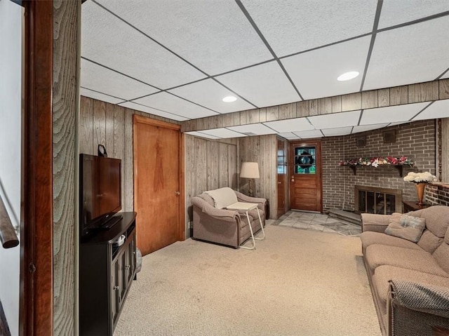 823 Clearview Dr, Penn Hills, PA 15147 - carpeted living area with a drop ceiling, wood walls, and a brick fireplace