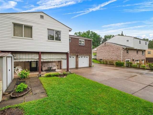 823 Clearview Dr, Penn Hills, PA 15147 - rear view of house featuring concrete driveway, an attached garage, a lawn, and brick siding