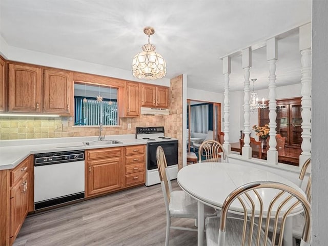 823 Clearview Dr, Penn Hills, PA 15147 - kitchen with white appliances, under cabinet range hood, light wood-style flooring, tasteful backsplash, and light countertops