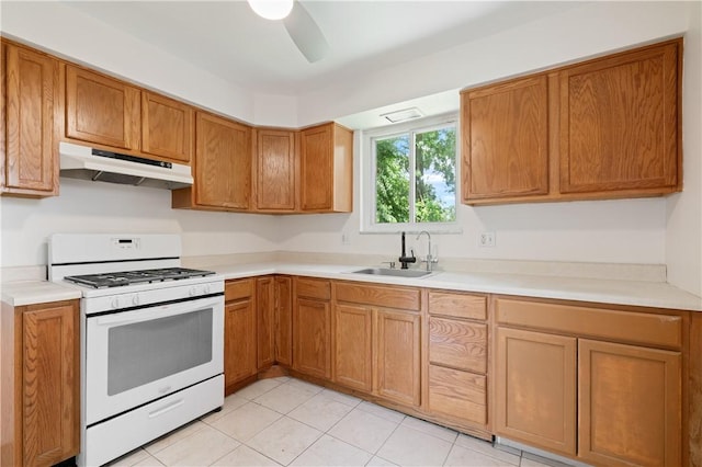 6623 Rosemoor St, Squirrel Hill, PA 15217 - kitchen featuring under cabinet range hood, white gas stove, light countertops, a ceiling fan, and brown cabinets