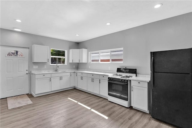 1406 Broadway Ave, Stowe Twp, PA 15136 - kitchen featuring freestanding refrigerator, range with gas cooktop, light countertops, white cabinetry, and light wood-style flooring