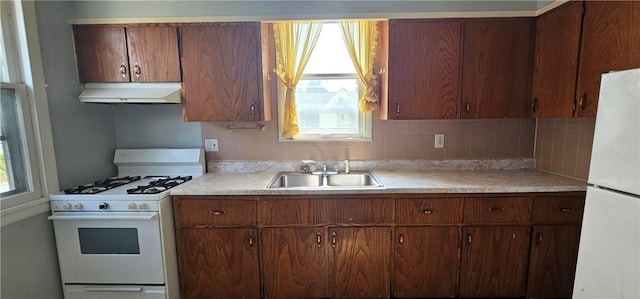 705 Carlisle St, New Castle, PA 16101 - kitchen featuring exhaust hood, white appliances, light countertops, and tasteful backsplash