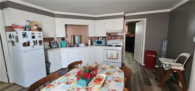 705 Carlisle St, New Castle, PA 16101 - kitchen with white appliances, under cabinet range hood, light countertops, dark wood-type flooring, and ornamental molding