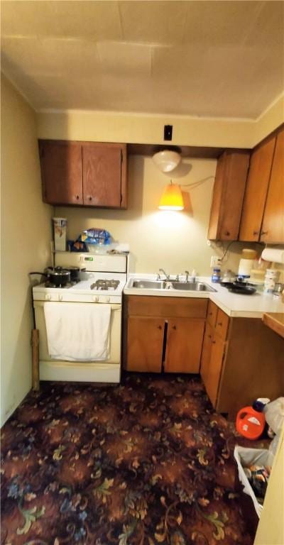 705 Carlisle St, New Castle, PA 16101 - kitchen featuring white gas range, brown cabinetry, and light countertops