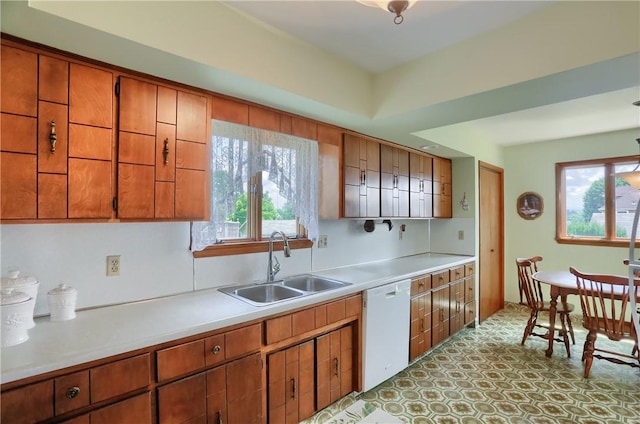 1020 Adams St, New Castle, PA 16101 - kitchen with white dishwasher, light countertops, brown cabinetry, and plenty of natural light