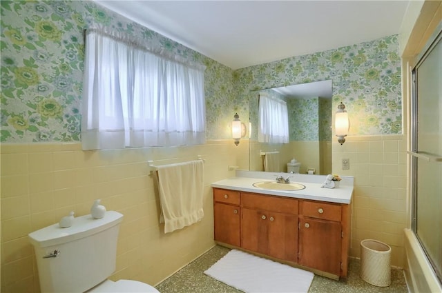 1020 Adams St, New Castle, PA 16101 - full bathroom featuring wallpapered walls, tile walls, vanity, a wainscoted wall, and bath / shower combo with glass door